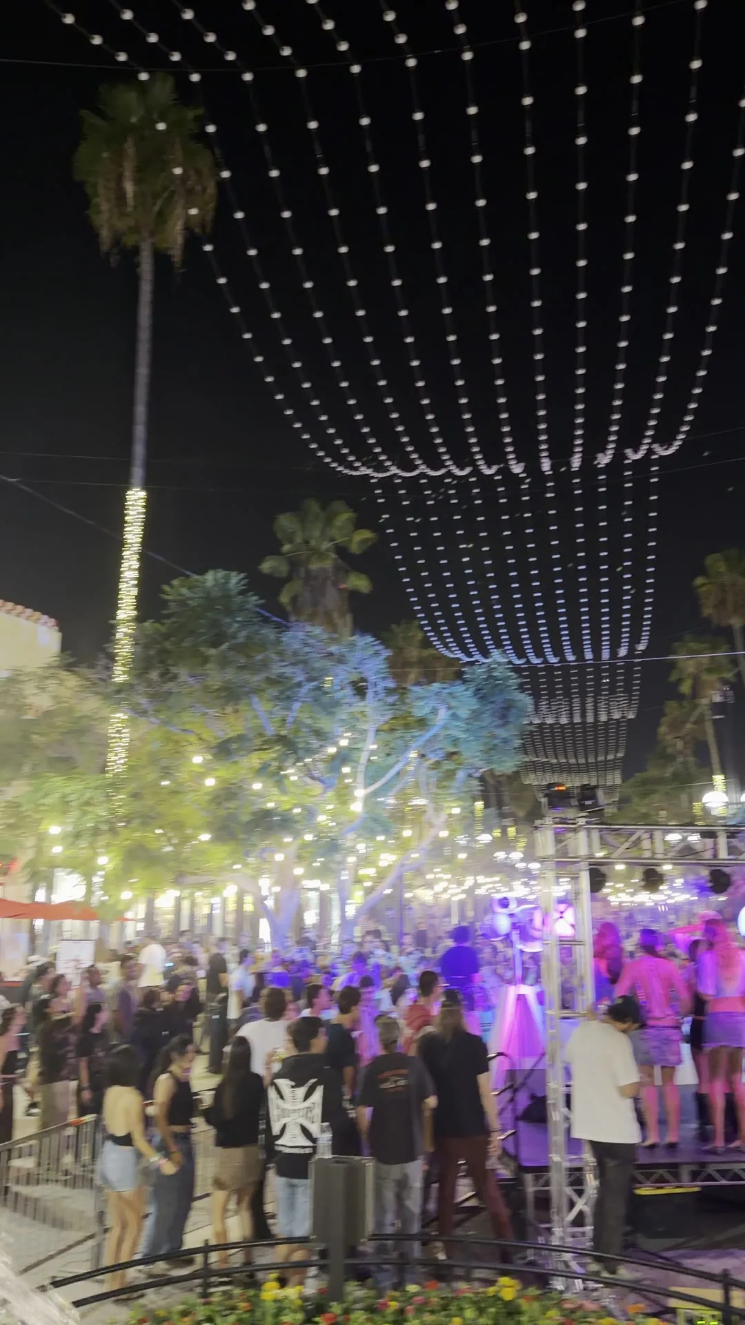 Packed street at night under canopy lights